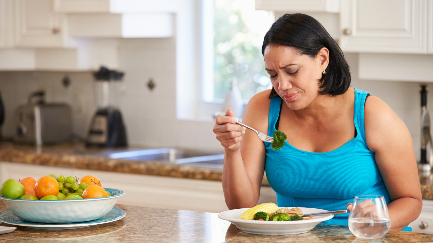 Fed Up Overweight Woman Eating Healthy Meal in Kitchen